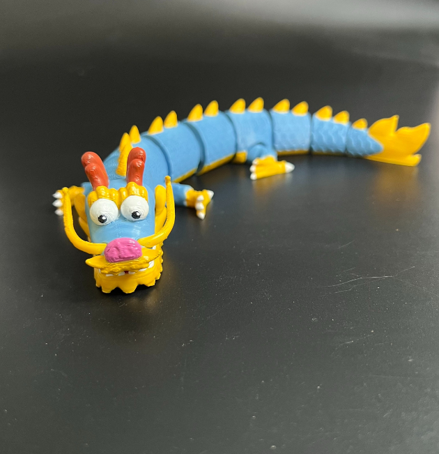 An articulated 3D-printed dragon with a cute and chubby design, featuring flexible movable parts.
