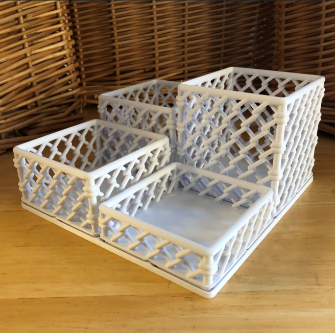 A modular set of white 3D-printed bins with a lattice design, perfect for organizing office supplies.
