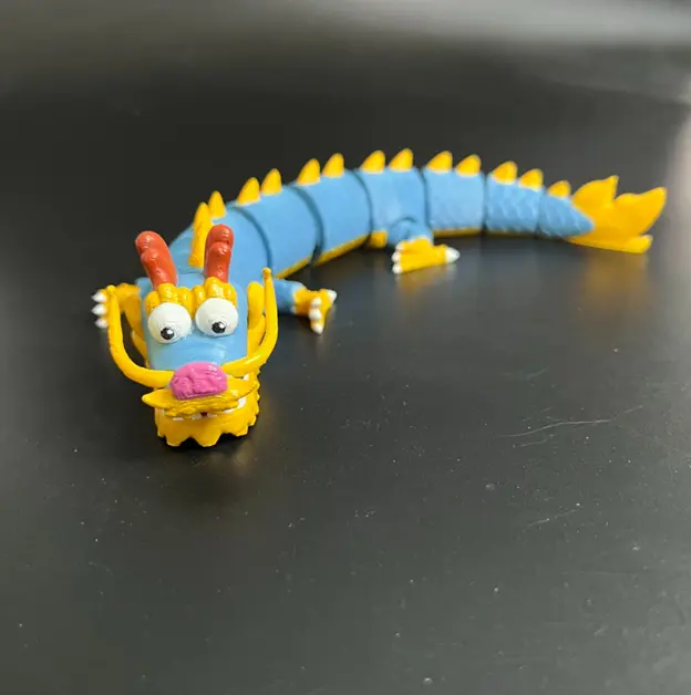 一隻色彩繽紛、充滿童趣的龍角色，身體細長分節，帶有藍色鱗片與黃色點綴。