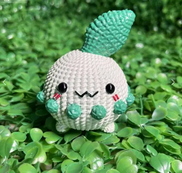 一隻小巧的白色生物，頭上有綠色葉片，臉頰帶淡藍色點綴，造型圓潤可愛。